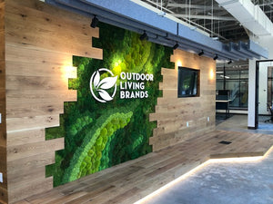 Moss and Wood Wall with White Logo in the Middle 