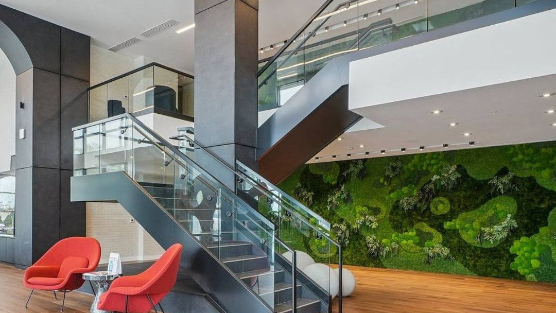 Modern interior with a staircase, red chairs, and a green wall